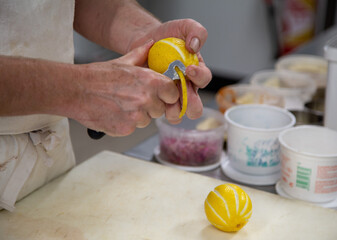 Chef cuisinier qui épluche des citrons en cuisine dans son restaurant