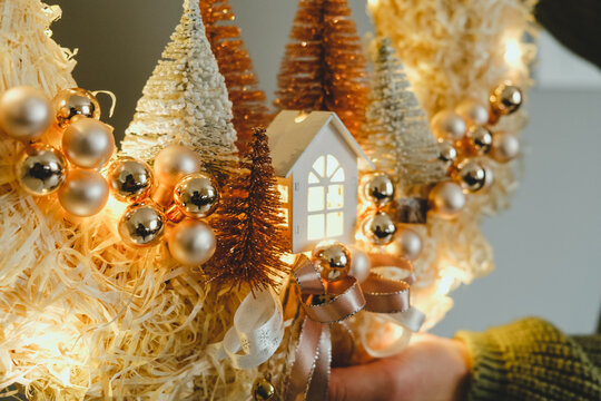 Handmade Christmas Wreath with Lights in Woman Hands for Winter holidays tradition, Lght garland, Natural and Ecofriendly Materials