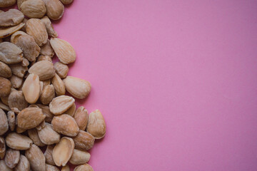 Almonds on a pink background viewed from above with copy space. Health and diet concept