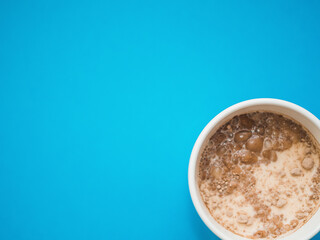 Top view a white mug with blue background. Copy space. Breakfast concept