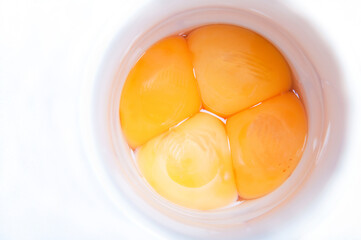 Four egg yolks in a white container