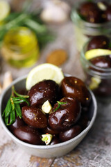Selective focus. Pickled plums in a bowl and jars. Plums with garlic and rosemary. Fermentation of plums. Gourmet appetizer soaked plums.