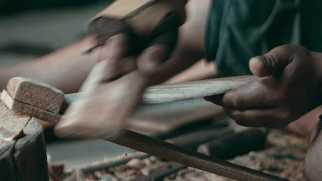 Nepalese craftsman grinding wooden piece by hand