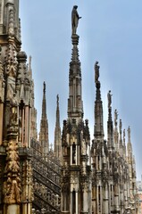 Fototapeta na wymiar Spectacular pinnacles and Gothic sculptures from Milan Cathedral, Italy