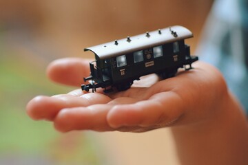 Train car toy model close-up held in palm by a child