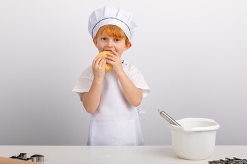 Junge mit roten Haaren hat Spaß beim Plätzchen backen.