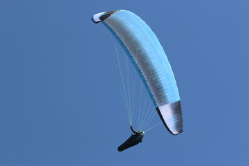 Paraglider flying wing in a blue sky	