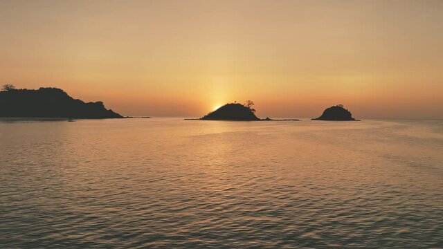 Timelapse of sunset seascape at mountain island silhouette aerial. Nobody nature landscape of Philippines, El Nido Isle, Visayas Archipelago. Waves at ocean bay. Sea waves at summer evening