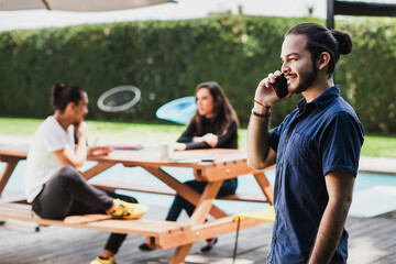Latin young businessman walking and talking on cell phone outdoors in Mexico