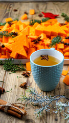 mockup blue cup with tea on a wooden background with new year decor in the background pumpkin sliced
