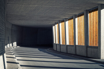 Avalanche gallery with wooden slats goes over into a dark concrete street tunnel