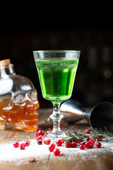 Absinthe is poured into a beautiful old glass, stands on the bar counter.