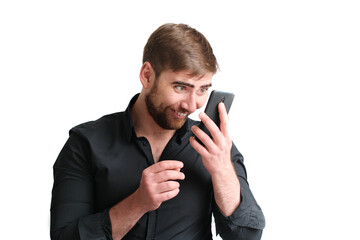 Portrait of young excited funny man in a black shirt looking at the phone on the isolated background