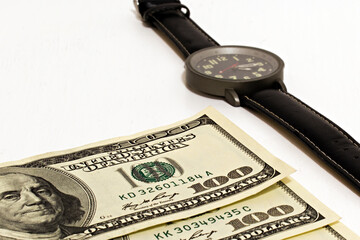 one hundred dollar bills and watches on white background with focus in the center of image