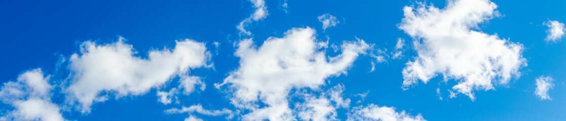 Obraz premium White clouds on a blue sky in bright colors, panorama