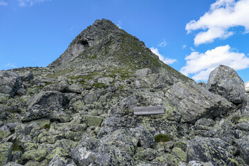 A view on Arlh&ouml;he peak from below in Maltal region in Austrian Alps. The peak is surrounded by lose stones and boulders. Difficult climbing. There is a wooden bench on the side. Hiking season