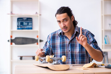 Young man repairing skateboard at workshop