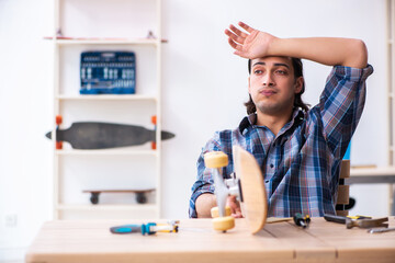 Young man repairing skateboard at workshop
