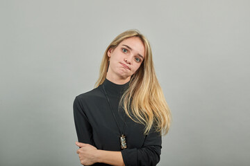 Standing and cross her arms on chest. Young attractive woman, dressed black sweater with green...