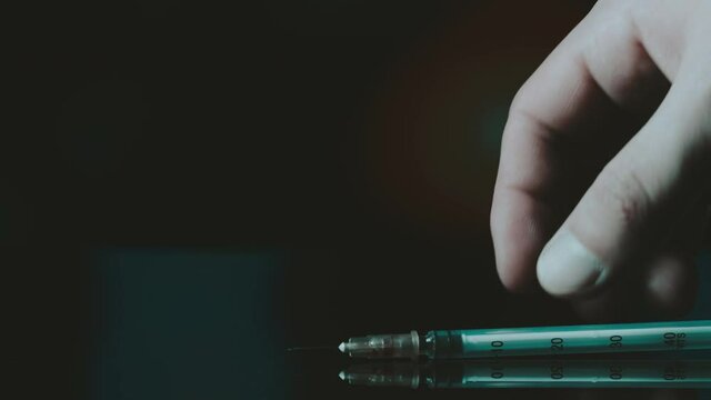 The addict puts the syringe on the table. Police sirens in the background.