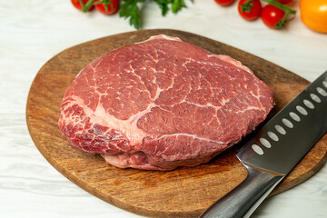 Two fresh raw rib-eye steak with rosmary in a rustic style background.