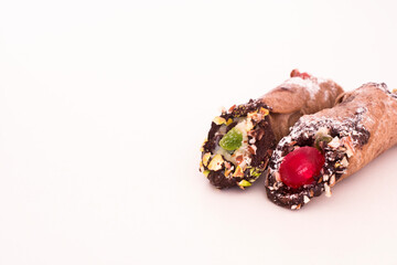 Sicilian Dessert cannoli made with cream cheese and pistachio on a white background.