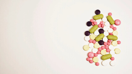 A pile of colorful pills on white background. Medical concept, illness, treatment.