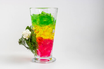 Puff jelly in a glass on a white background with green branches of spruce and white berries of brilliant dogwood