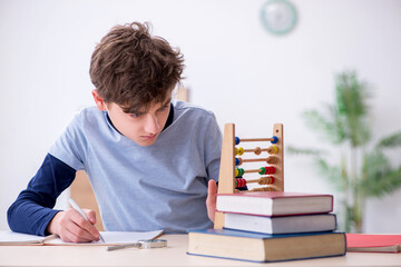 Schoolboy with abacus studying math at home