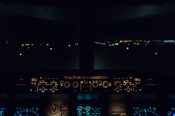 Aircraft cockpit flight deck at night on runway