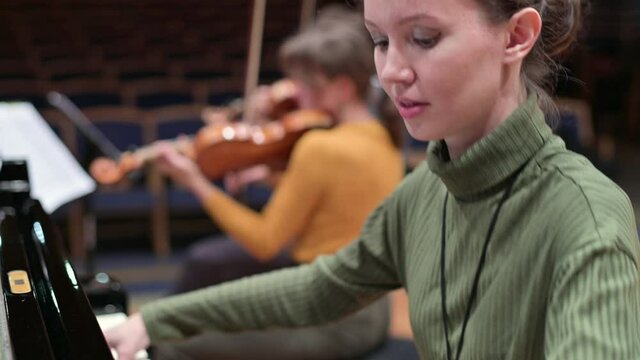 Close-up of the face of a pianist rehearsing a performance with a string quartet