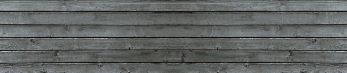Fototapeta na wymiar Texture of old gray wood, background of boards, panorama of an old burnt out wooden house.