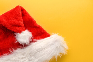 Obraz na płótnie Canvas Red Santa Claus hat on a bright yellow background. New year and Christmas background