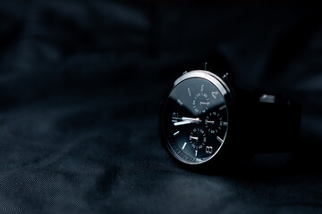 Reloj de pulsera negro elegante sobre fondo negro. Accesorios para hombre.