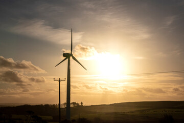 Obraz premium a wind turbine spinning in the sunset providing clean green energy