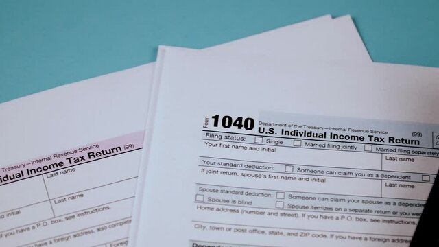Individual income tax return forms 1040a and 1040 next to calculator. Close-up