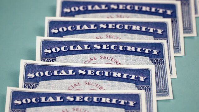 Several Social security cards lie in a row. Vertical move video shot. Close-up