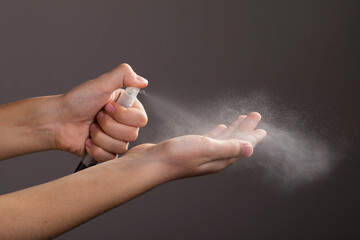 Boy spraying antiseptic spray on hands to prevent infection