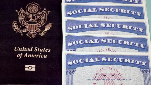 Several Social security cards lie in a row next to the passport of a citizen of the United States. Vertical move video shot. Close-up