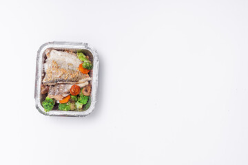 healthy food delivery or takeaway lunch box with fish, lettuce and tomato cherry