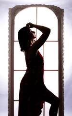 Fototapeta na wymiar Woman's beautiful sihouette on white window background