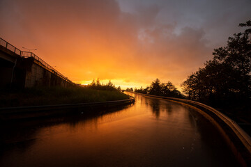 Fototapeta na wymiar wet reflected road in sunset