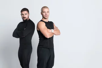 Gordijnen two athletic personal fitness trainers or bodybuilders on white background © goami