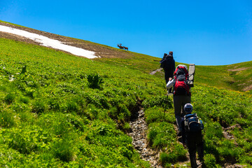 Beautiful mountain landscape with tourists hiking at Caucasus mountains.