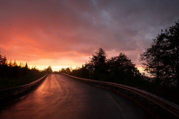 Obraz premium wet reflected road in sunset