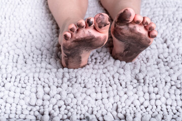 dirty kid feet on a fluffy mat.daily life dirty stain for wash and clean concept