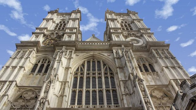 Time lapse of westminster abbey in London United Kingdom  during a sunny cloudy day. There is the tower in close up and the clouds in background