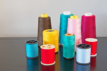 A group of assorted bobbins with bright, multicolored threads for sewing, needlework and tailoring.