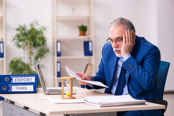 Naklejka premium Old male employee businessman in time management concept