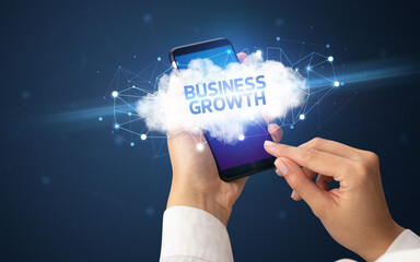 Female hand touching smartphone with BUSINESS GROWTH inscription, cloud business concept